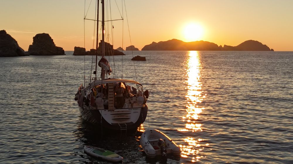 Foto della nostra barca a vela ormeggiata davanti ad un tramonto per il ponte del 1 maggio